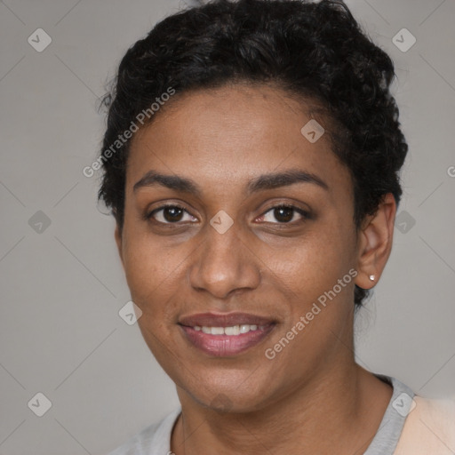 Joyful black young-adult female with short  black hair and brown eyes