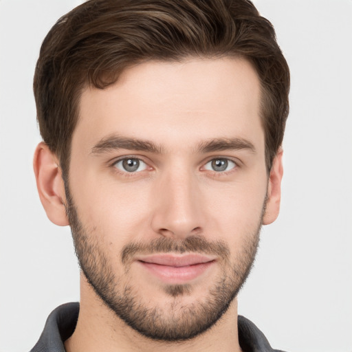 Joyful white young-adult male with short  brown hair and grey eyes