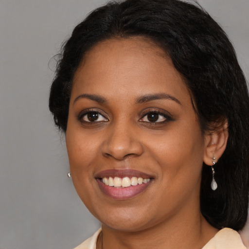 Joyful black young-adult female with medium  brown hair and brown eyes