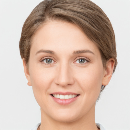 Joyful white young-adult female with short  brown hair and grey eyes