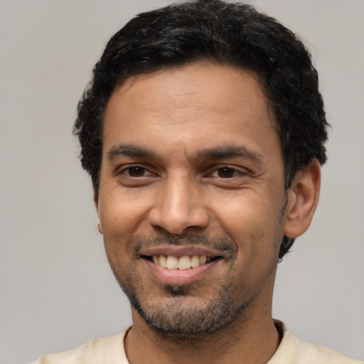 Joyful latino young-adult male with short  black hair and brown eyes