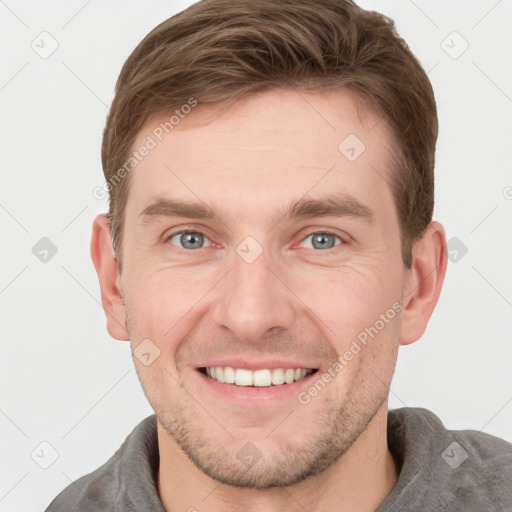 Joyful white young-adult male with short  brown hair and grey eyes