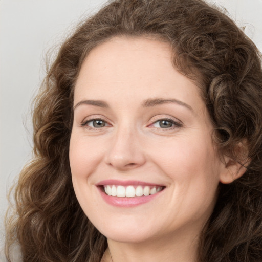 Joyful white young-adult female with long  brown hair and green eyes