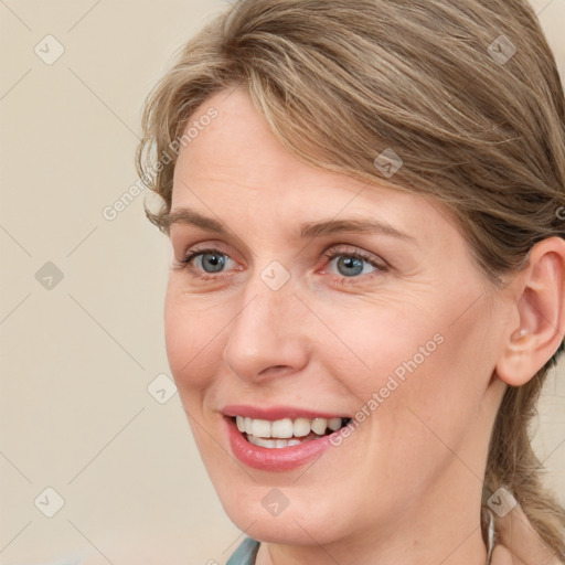 Joyful white adult female with medium  brown hair and blue eyes