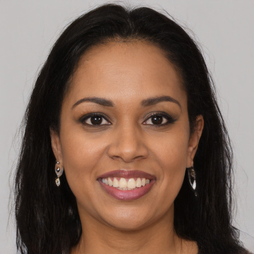 Joyful latino young-adult female with long  brown hair and brown eyes