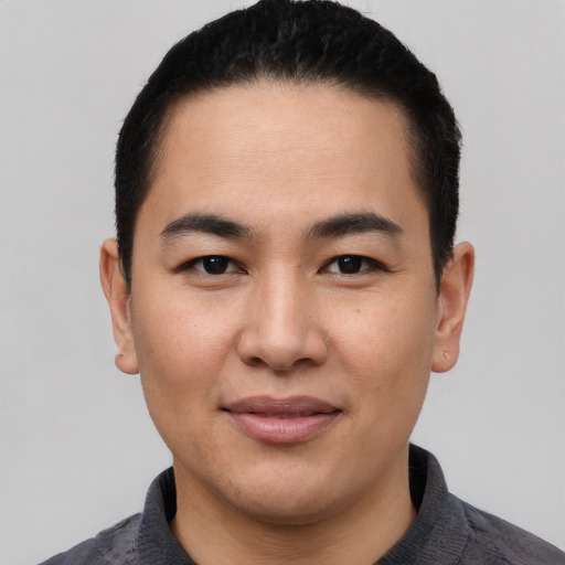Joyful asian young-adult male with short  black hair and brown eyes