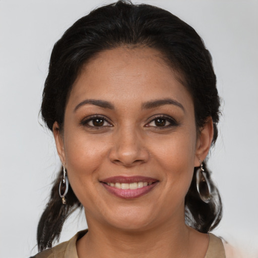 Joyful latino young-adult female with medium  brown hair and brown eyes