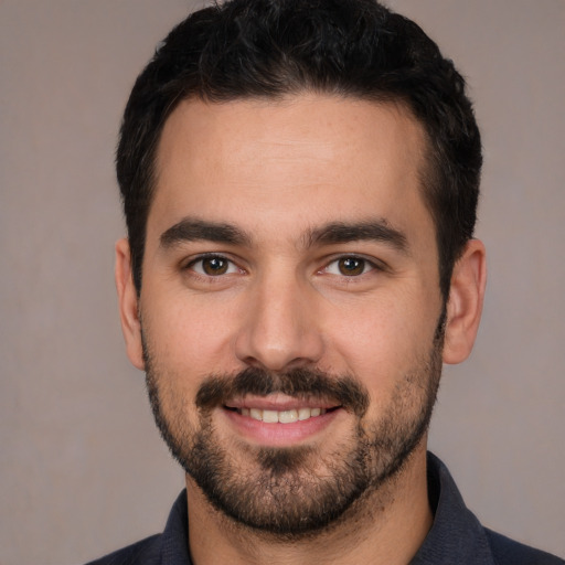 Joyful white young-adult male with short  black hair and brown eyes