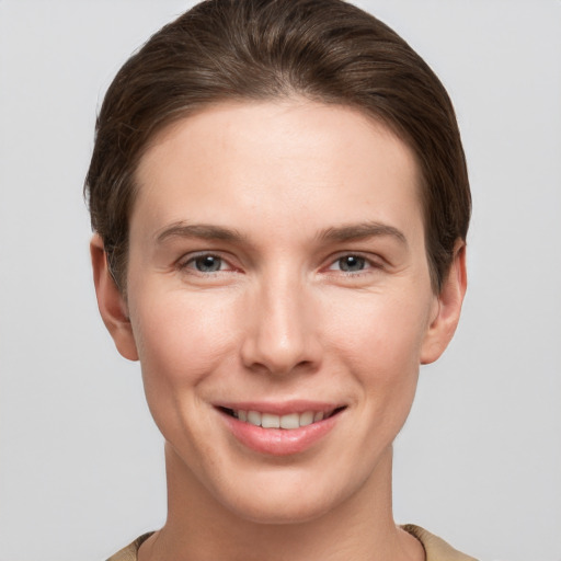 Joyful white young-adult female with short  brown hair and grey eyes