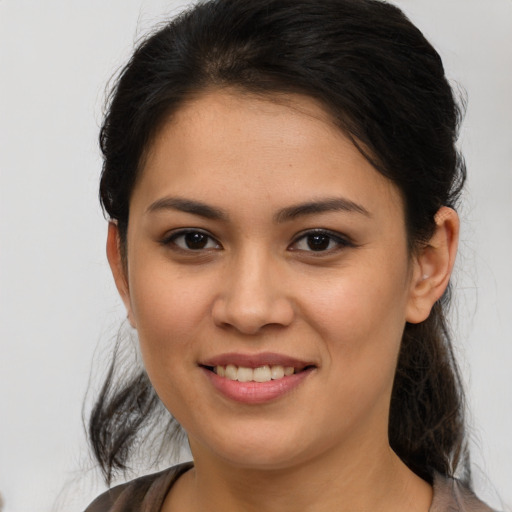 Joyful latino young-adult female with medium  brown hair and brown eyes