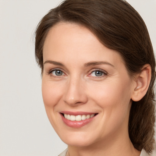 Joyful white young-adult female with medium  brown hair and grey eyes