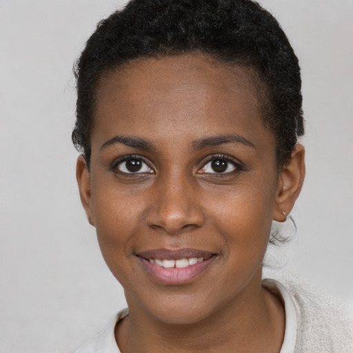Joyful black young-adult female with short  brown hair and brown eyes