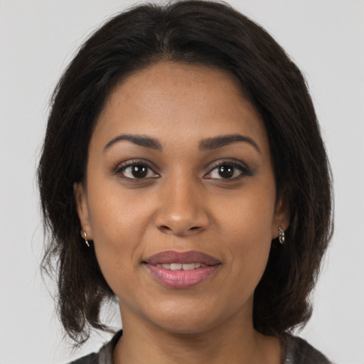Joyful black young-adult female with medium  brown hair and brown eyes
