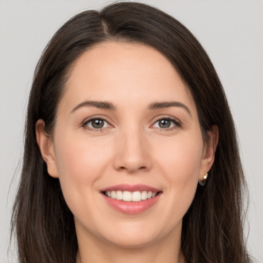 Joyful white young-adult female with long  brown hair and brown eyes