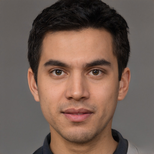 Joyful white young-adult male with short  black hair and brown eyes