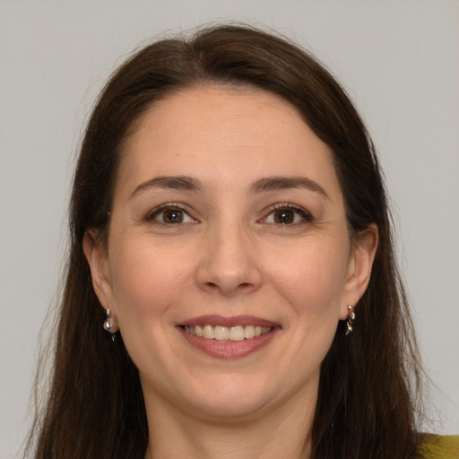 Joyful white young-adult female with long  brown hair and brown eyes