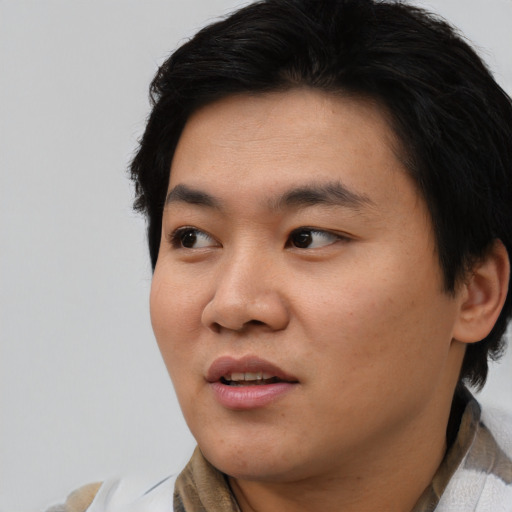 Joyful asian young-adult male with short  black hair and brown eyes