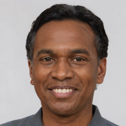 Joyful latino adult male with short  black hair and brown eyes