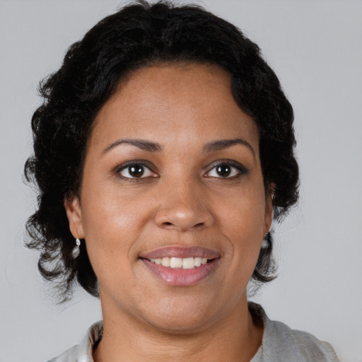 Joyful black adult female with medium  brown hair and brown eyes