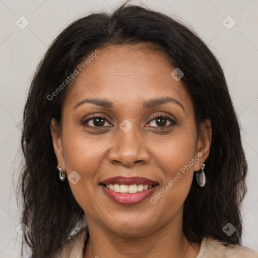 Joyful black adult female with long  brown hair and brown eyes