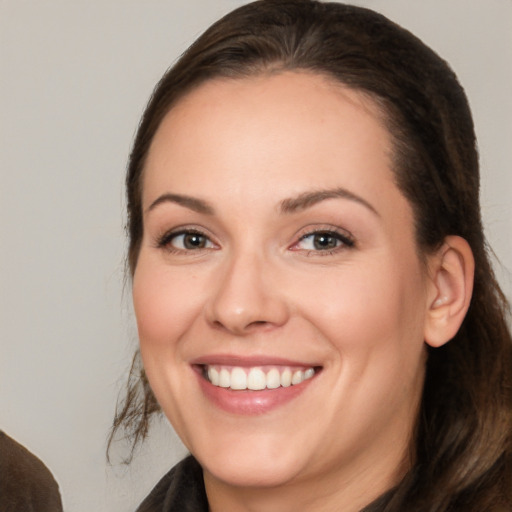 Joyful white young-adult female with long  brown hair and brown eyes