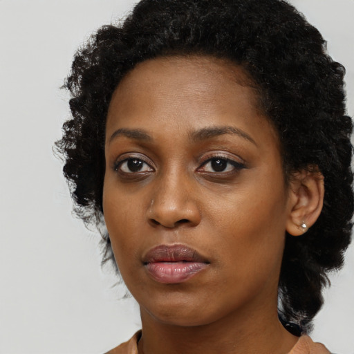 Joyful black young-adult female with long  black hair and brown eyes