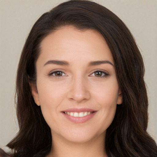 Joyful white young-adult female with long  brown hair and brown eyes