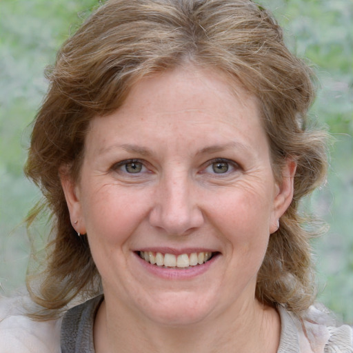 Joyful white adult female with medium  brown hair and blue eyes