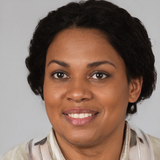 Joyful black adult female with medium  brown hair and brown eyes