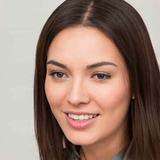 Joyful white young-adult female with long  brown hair and brown eyes