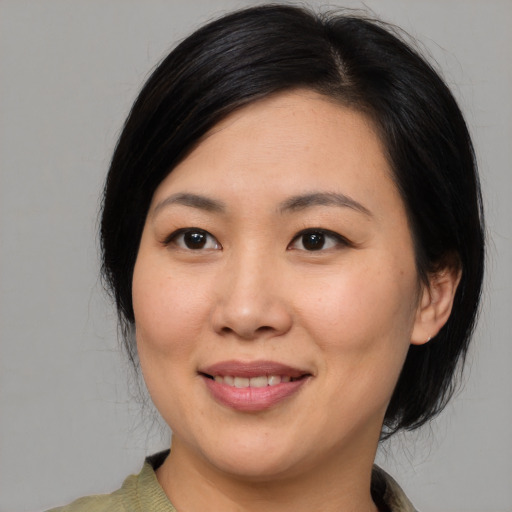 Joyful asian young-adult female with medium  black hair and brown eyes