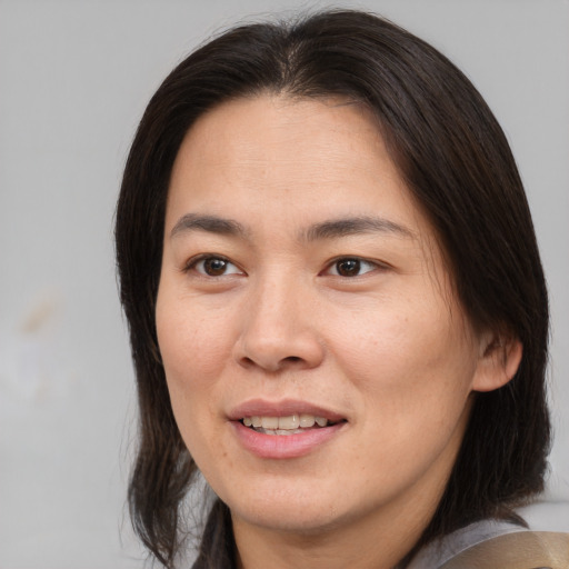 Joyful asian adult female with medium  brown hair and brown eyes