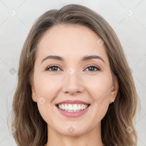 Joyful white young-adult female with long  brown hair and grey eyes