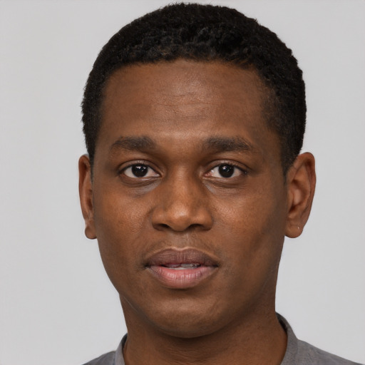 Joyful black young-adult male with short  black hair and brown eyes
