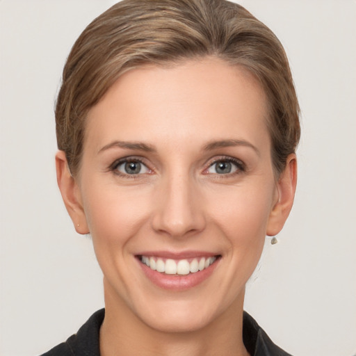 Joyful white young-adult female with short  brown hair and grey eyes