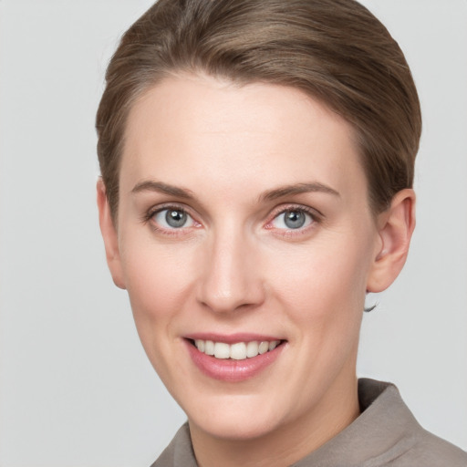 Joyful white young-adult female with short  brown hair and grey eyes