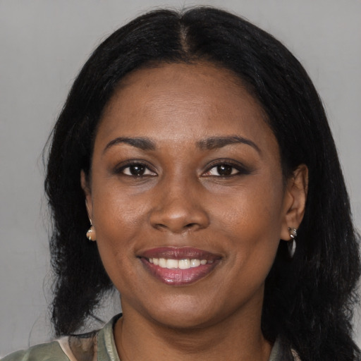 Joyful black adult female with medium  black hair and brown eyes