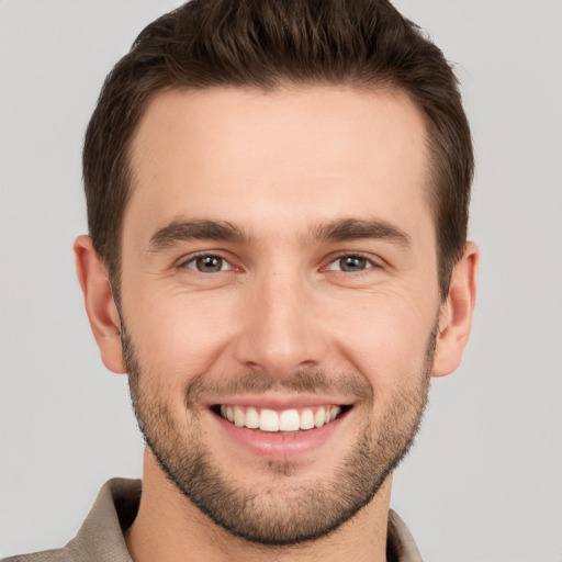 Joyful white young-adult male with short  brown hair and brown eyes