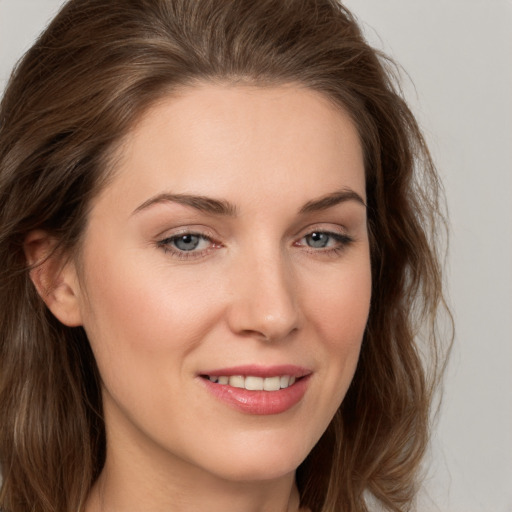 Joyful white young-adult female with long  brown hair and grey eyes