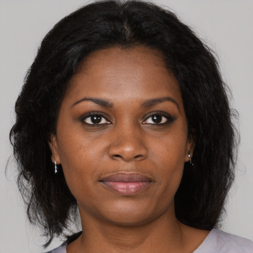 Joyful black young-adult female with medium  brown hair and brown eyes