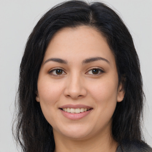 Joyful latino young-adult female with long  brown hair and brown eyes