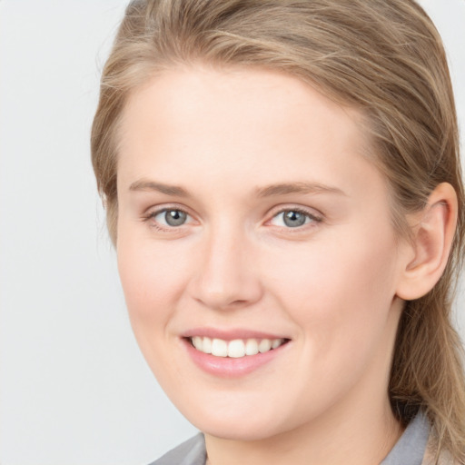 Joyful white young-adult female with medium  brown hair and blue eyes