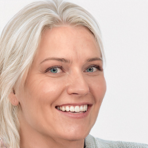 Joyful white adult female with medium  blond hair and blue eyes