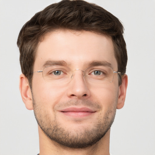 Joyful white young-adult male with short  brown hair and grey eyes