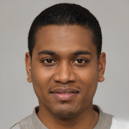 Joyful black young-adult male with short  black hair and brown eyes