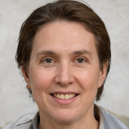 Joyful white adult female with medium  brown hair and grey eyes