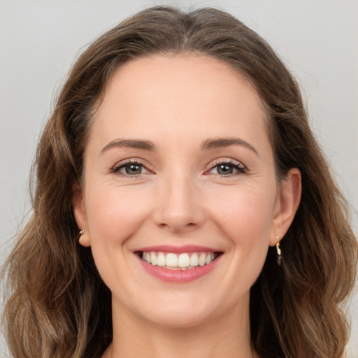 Joyful white young-adult female with long  brown hair and green eyes