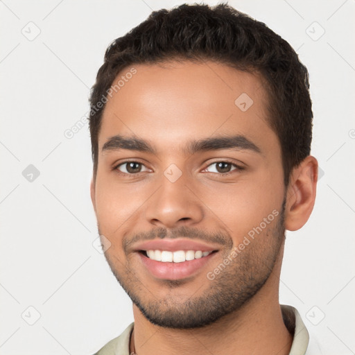 Joyful latino young-adult male with short  brown hair and brown eyes