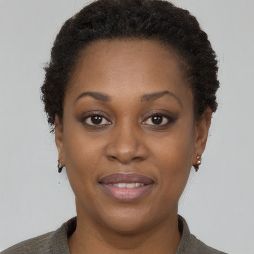 Joyful black young-adult female with short  brown hair and brown eyes