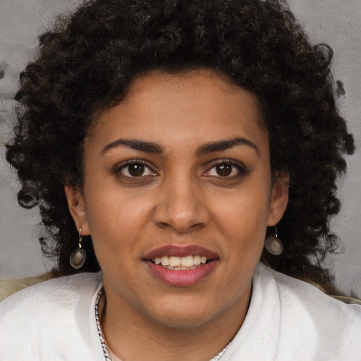 Joyful black young-adult female with long  brown hair and brown eyes